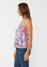 [Color: Natural/Dusty Pink] A side facing image of a brunette model wearing a spring floral cami with a scoop neckline, fixed straps, and a button front. 