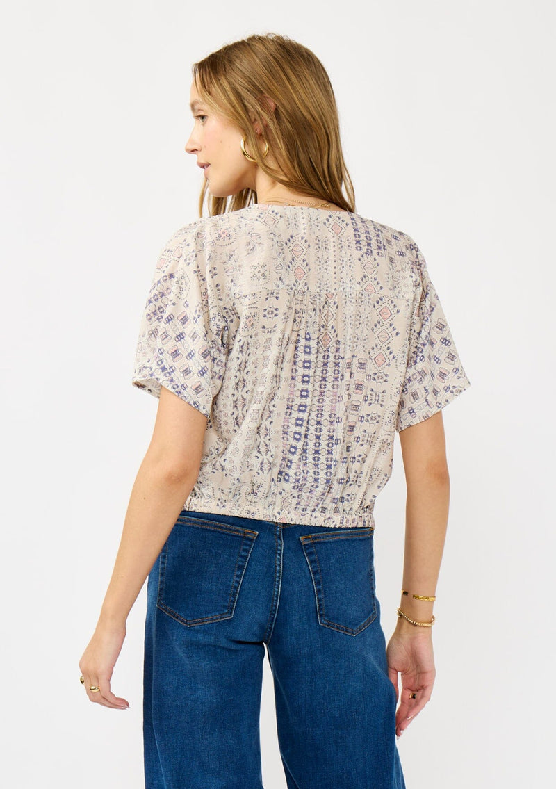 [Color: Oatmeal/Plum] A back facing image of a blonde model wearing a boho floral tie front top with short dolman sleeves, a v-neckline, and button front. 