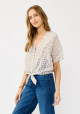 [Color: Oatmeal/Plum] A side facing image of a blonde model wearing a boho floral tie front top with short dolman sleeves, a v-neckline, and button front. 