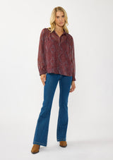 [Color: Wine/Rose] A front facing image of a blonde model wearing a floral diamond print chiffon blouse with metallic thread details. Featuring metallic thread details, a button front, and long sleeves with a tailored cuff. A special occasion top for the fall season. 