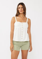 [Color: White] A front facing image of a brunette model wearing a white boho tank top with a smocked back, button front, an eyelet trim, and pintuck details. Perfect for everyday spring styling. 