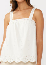 [Color: White] A detail image of a blonde model wearing a white cotton eyelet tank top with adjustable straps and a scalloped hem. 