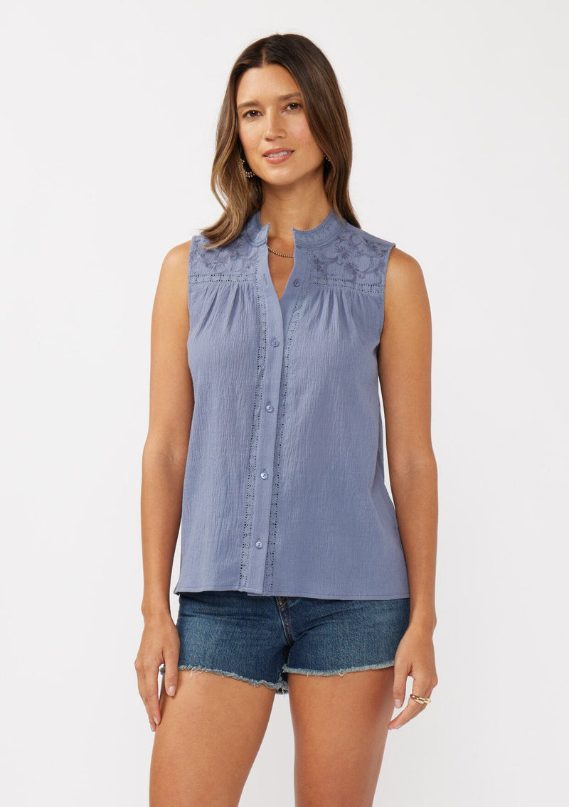[Color: Denim Blue] A front facing image of a brunette model wearing a blue classic boho tank top with a button front, embroidered yoke, and lace trim accents. 