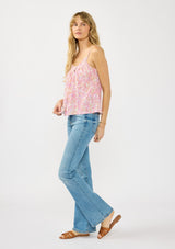 [Color: Natural/Dusty Rose] A side facing image of a blonde model wearing a pink floral print camisole with a smocked neckline, button front, and adjustable spaghetti straps. 