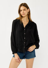 [Color: Black] A front facing image of a blonde model wearing a soft vintage wash black shirt with tonal embroidered details. Featuring a classic collar neckline, button front, and button cuff. 