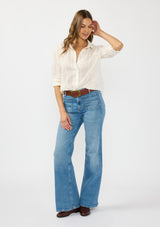[Color: White/Natural] A front facing image of a brunette model wearing a white embroidered shirt with a button front and collar. 