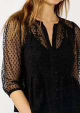 [Color: Black] A detail image of a blonde model wearing a Victorian mixed lace top with 3/4 length sleeves, a split v-neckline, button front, and a subtle peplum-style silhouette. A versatile black fall lace top. 