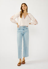 [Color: Pale Rose] A front facing image of a blonde model wearing a light pink blouse with floral embroidery, lace accents, and a flattering split v-neckline. Effortlessly boho and feminine for casual outings. 