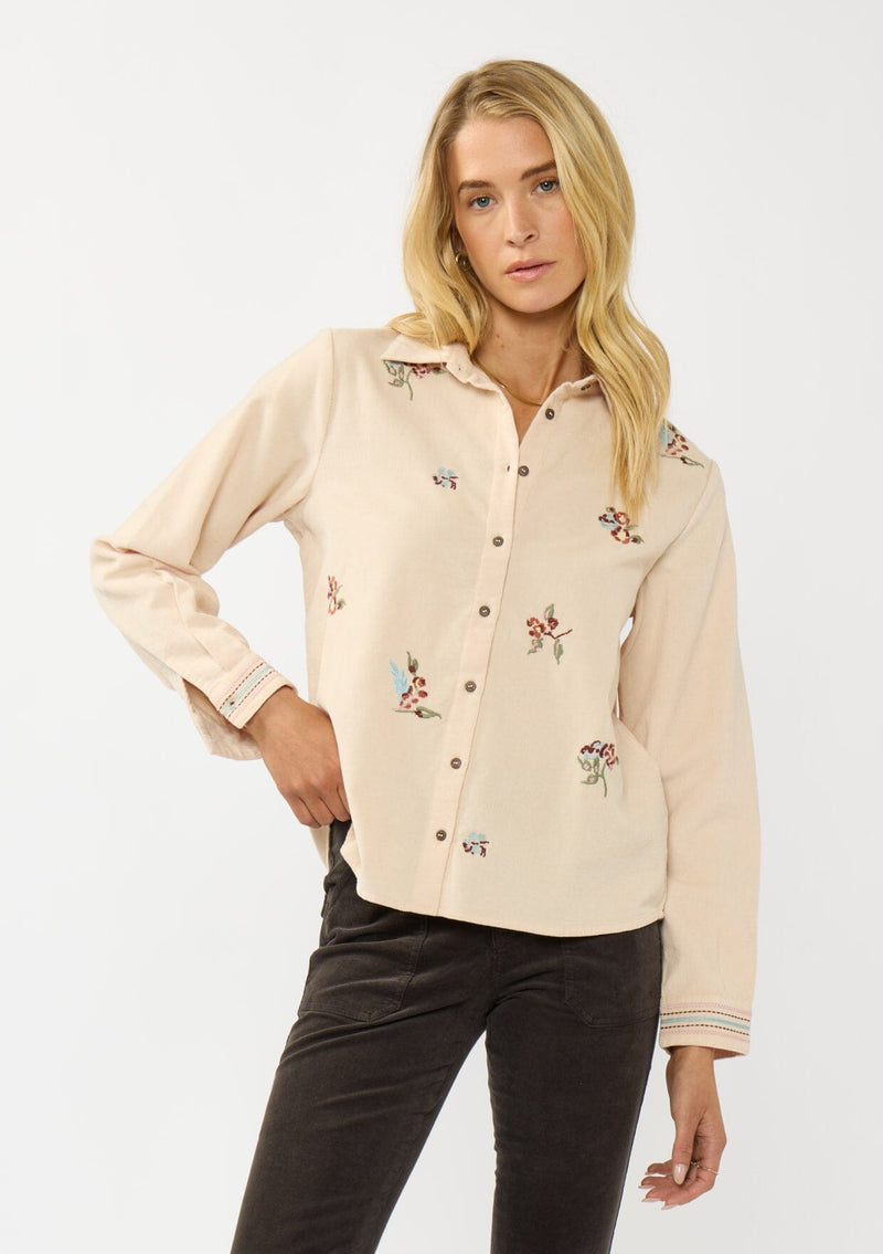 [Color: Vanilla] A front facing image of a blonde model wearing a corduroy shirt with floral embroidery, a button front, and a collar neck. A soft and comfortable western inspired shirt for the fall season. 