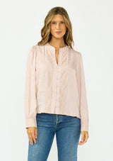 [Color Dusty Rose] A front facing image of a brunette model wearing a satin jacquard blouse with a button front and lace trims. 