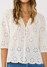 [Color: White] A detail image of a brunette model wearing a white eyelet embroidered top with half sleeves and a button front. A classic spring top styled with denim. 