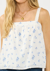 [Color: White/Blue] A detail image of a white blue floral tank top with adjustable straps, lace trim, and a square neckline. 