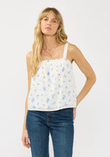 [Color: White/Blue] A front facing image of a white blue floral tank top with adjustable straps, lace trim, and a square neckline. 
