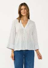 [Color: White/Denim Blue] A front facing  image of a brunette model wearing a blue and white striped blouse with a v neckline, button front, and long wide sleeves. 