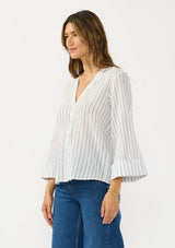 [Color: White/Denim Blue] A side facing  image of a brunette model wearing a blue and white striped blouse with a v neckline, button front, and long wide sleeves. 