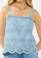 [Color: Ocean Blue] A front facing image of a blonde model wearing a light blue eyelet top with adjustable straps and pintuck details.