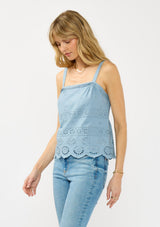 [Color: Ocean Blue] A side facing image of a blonde model wearing a light blue eyelet top with adjustable straps and pintuck details.