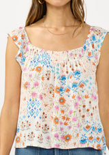[Color: Ivory/Orange] A detail image of a brunette model wearing a blue and orange floral top with cap sleeves and a smocked scoop neckline. 