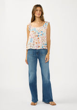 [Color: Ivory/Orange] A front facing image of a brunette model wearing a blue and orange floral top with cap sleeves and a smocked scoop neckline. Styled with patch pocket denim.