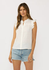 [Color: Off White] A front facing image of a brunette model wearing a cotton white top with a button front, an eyelet yoke, and flutter cap sleeves. Airy and relaxed for the spring season.