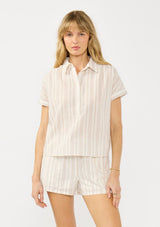 [Color: Sand/Off White] A front facing image of a blonde model wearing a cotton striped shirt with a puckered texture, collar neck, button front, and short sleeves. Styled with matching shorts. 