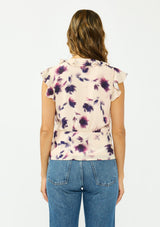 [Color: Peach/Plum] A back facing image of a brunette model wearing a pink and purple floral top with flutter sleeves, a v neckline with ruffle trim, and a tie front detail. 