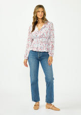 [Color: Grey/Dusty Rose] A front facing image of a brunette model wearing a floral print peplum top with a split neckline and a shirred elastic waist. 