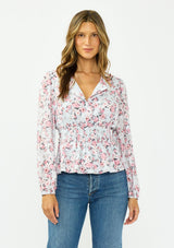 [Color: Grey/Dusty Rose] A front facing image of a brunette model wearing a floral print peplum top with a split neckline and a shirred elastic waist. 