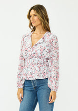 [Color: Grey/Dusty Rose] A side facing image of a brunette model wearing a floral print peplum top with a split neckline and a shirred elastic waist. 