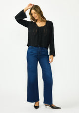 [Color: Black] A front facing image of a brunette model wearing a black lace long sleeve top with a scoop neckline and button front. 