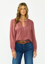 [Color: Rose Brown] A front facing image of a brunette model wearing a bohemian embroidered blouse with lace and pintuck details. Paired with a dark wash denim. 