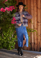 [Color: Wine/Navy] A full body front facing image of a brunette model standing outside wearing a classic shirt jacket in a wine red and navy blue patchwork plaid. A soft fall and winter jacket with long sleeves, front patch flap pockets, a collared neckline, a button up front, and side pockets.