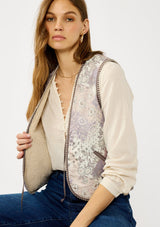 [Color: Natural/Lavender] A front facing image of a blonde model wearing a light purple cozy fall floral sherpa vest with a tie front detail and side pockets. Perfect for layering any boho look. 