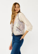 [Color: Natural/Lavender] A side facing image of a blonde model wearing a cozy fall floral sherpa vest with a tie front detail and side pockets. Perfect for layering any boho look. 