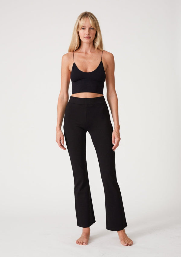 [Color: Black] A front facing image of a blonde model wearing a slim fit black flared legging designed in Ponte. With an elastic waist. 