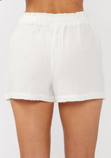 [Color: White] A back facing image of white cotton gauze shorts with an elastic drawstring waist and side pockets. Perfect for spring, lounging, or beach days. 