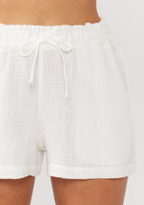 [Color: White] A detail image of white cotton gauze shorts with an elastic drawstring waist and side pockets. Perfect for spring, lounging, or beach days. 