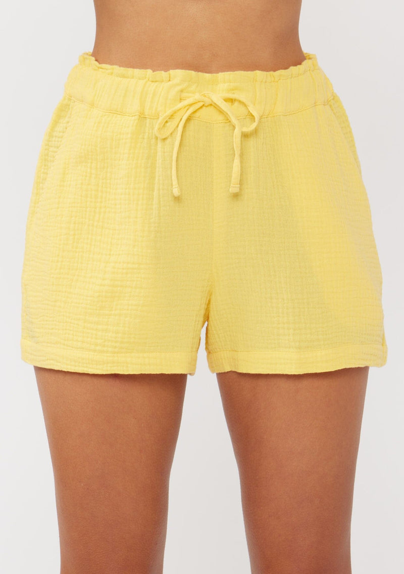 [Color: Yellow] A front facing image of yellow cotton gauze shorts with an elastic drawstring waist and side pockets. Perfect for spring, lounging, or beach days. 