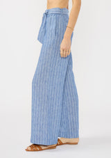 [Color: Blue] A side facing image of a model wearing a blue striped bottom with a belt, elastic waist, and side pockets. 