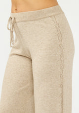 [Color: Heather Taupe] A side facing image of a beige knit pant with a drawstring waist and a side cable knit detail.