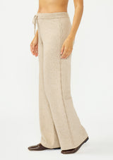 [Color: Heather Taupe] A side facing image of a beige knit pant with a drawstring waist and a side cable knit detail.