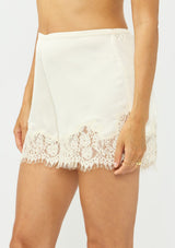 [Color: Champagne] A side facing image of an off white satin lace short. 