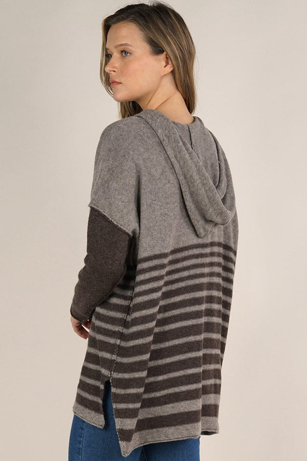 [Color: Cement/Dark Chocolate] An image of a blonde model wearing a grey and brown striped pullover hoodie with a contrast sleeve, drawstring, and kangaroo pockets. Casual and laid back for the fall season. 