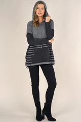 [Color: Grey/Charcoal] An image of a blonde model wearing a grey striped pullover hoodie with a contrast sleeve, drawstring, and kangaroo pockets. Casual and laid back for the fall season. 