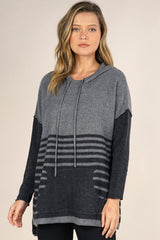 [Color: Grey/Charcoal] An image of a blonde model wearing a grey striped pullover hoodie with a contrast sleeve, drawstring, and kangaroo pockets. Casual and laid back for the fall season. 