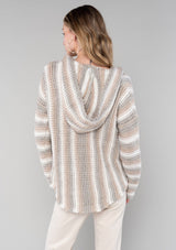 [Color: Ash/Cream] A back facing image of a blonde model wearing a vertical striped knit pullover with a hoodie, relaxed v-neckline, and cozy long sleeves. A classic knit sweater for casual outings. 