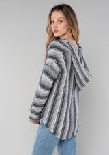 [Color: Smoke/Steel] A side facing image of a blonde model wearing a vertical striped knit pullover with a hoodie, relaxed v-neckline, and cozy long sleeves. A classic knit sweater for casual outings. 
