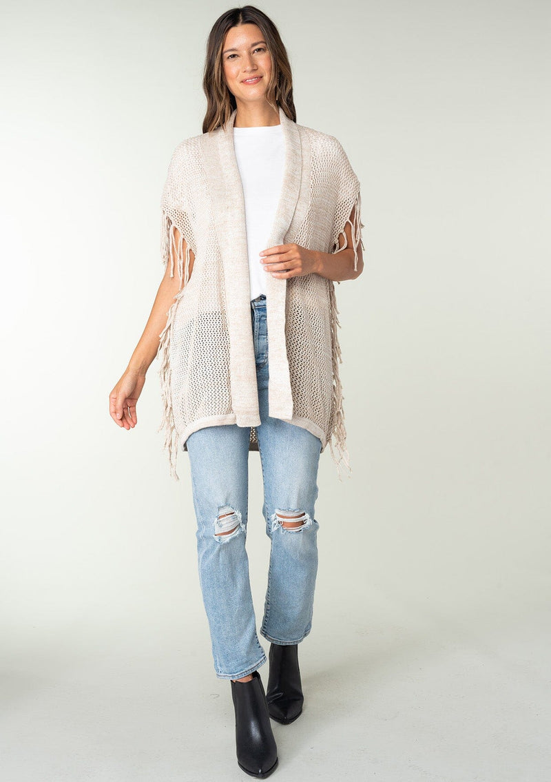 [Color: Bone] A front facing image of a brunette model wearing a open knit lightweight cardigan with fringe accents. An easy throw on for casual outings. 