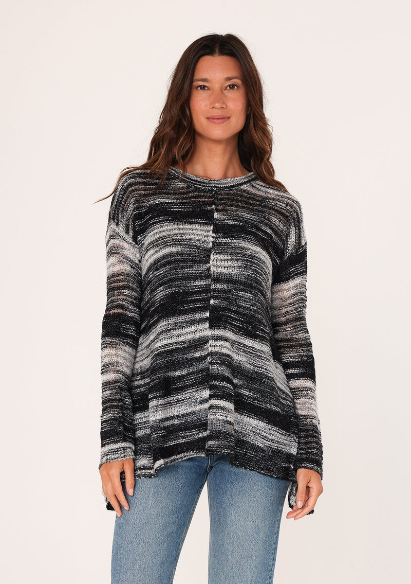 [Color: Black/Grey] A front facing image of a brunette model wearing a relaxed melange knit sweater. This lightweight sweater features a round neckline, a swing hem, and comfortable long sleeves with dropped shoulders. 