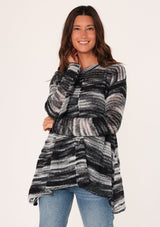 [Color: Black/Grey] A front facing image of a brunette model wearing a relaxed melange knit sweater. This lightweight sweater features a round neckline, a swing hem, and comfortable long sleeves with dropped shoulders. 